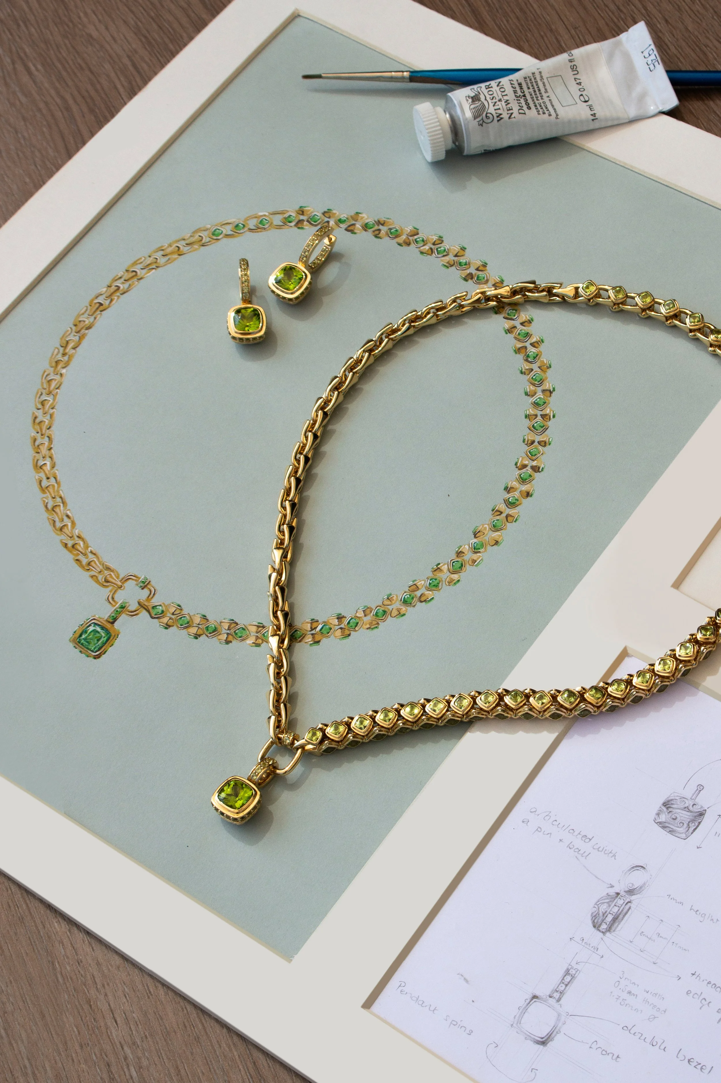 18K Yellow gold award winning necklace design, with the original artwork and matching earrings, set with Fuli peridot gemstone by Sophie Cudworth