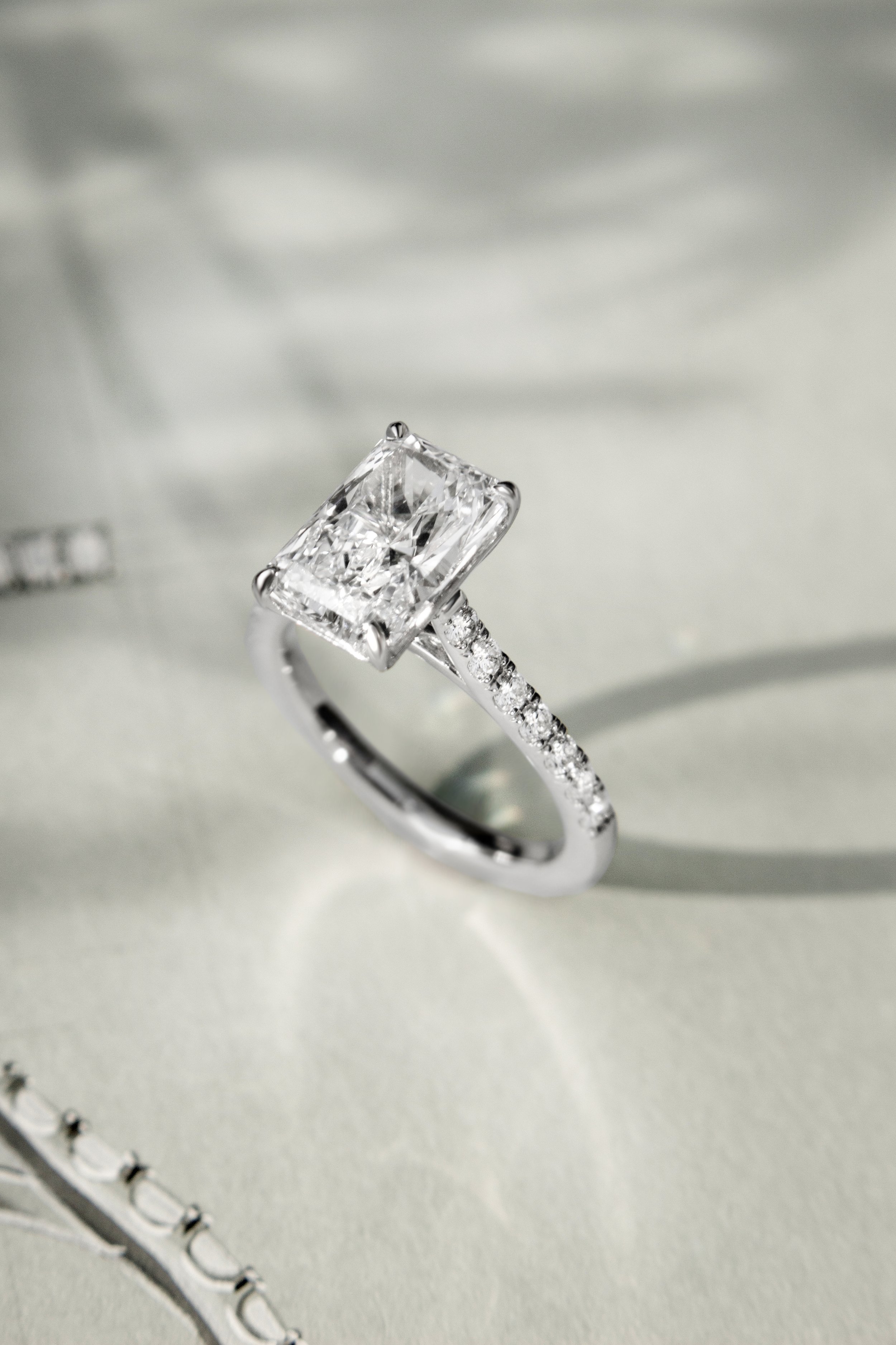 Platinum ring by Sophie Cudworth set with 3ct radiant cut diamond and diamond set shoulders