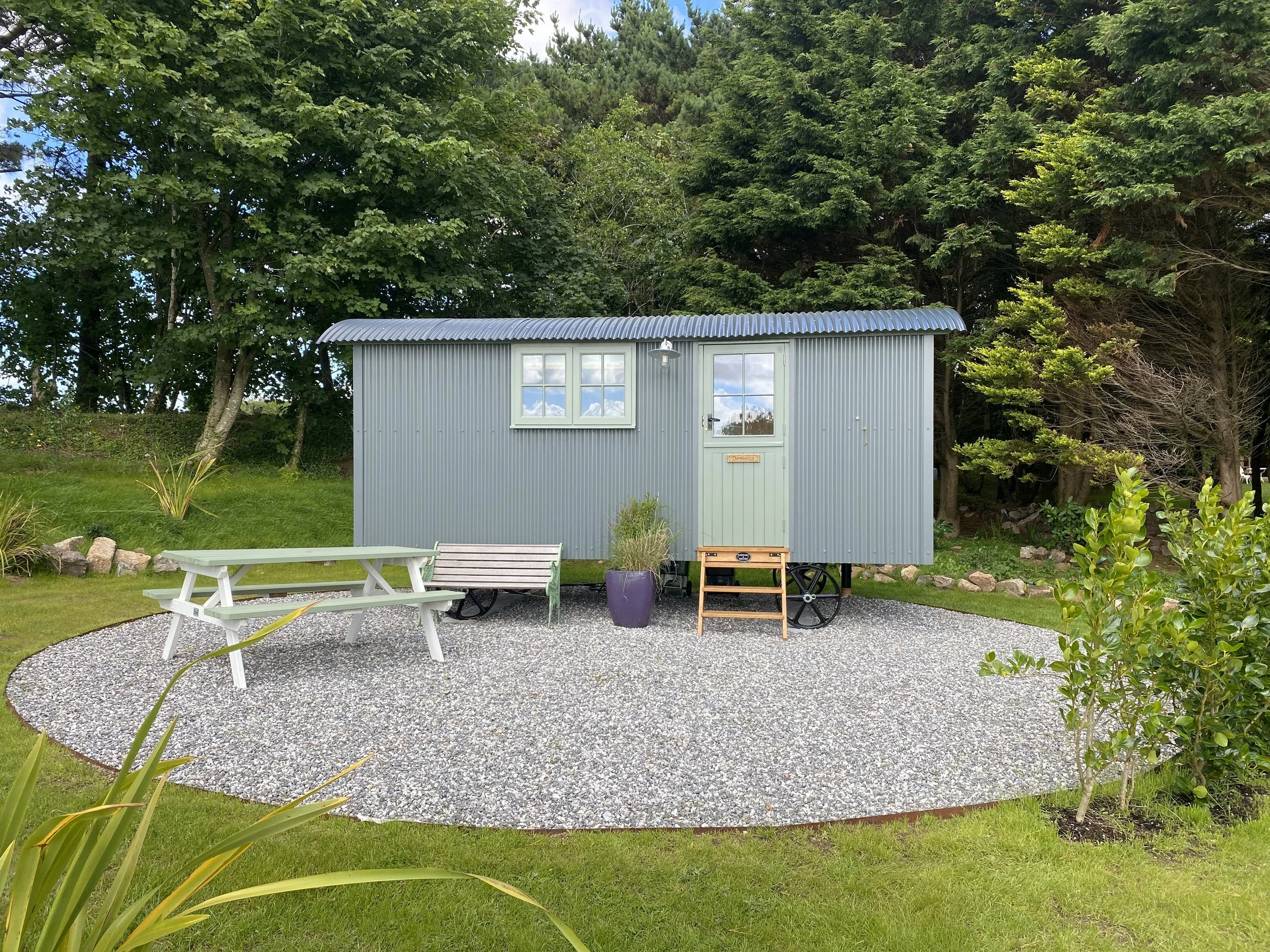 Demelza's outside space with picnic table and bench.JPG