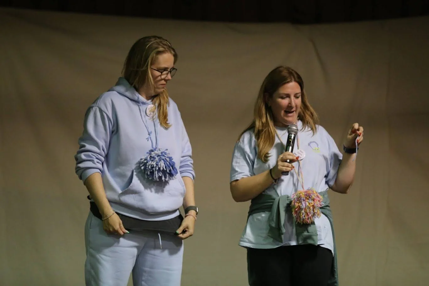 Alex and team partner standing on a stage talking to the audience during a recent mental health presentation.