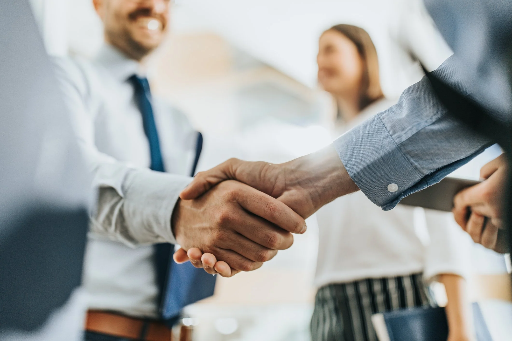 Two business professionals shaking hands symbolizing partnership and agreement in real estate investment.jpg
