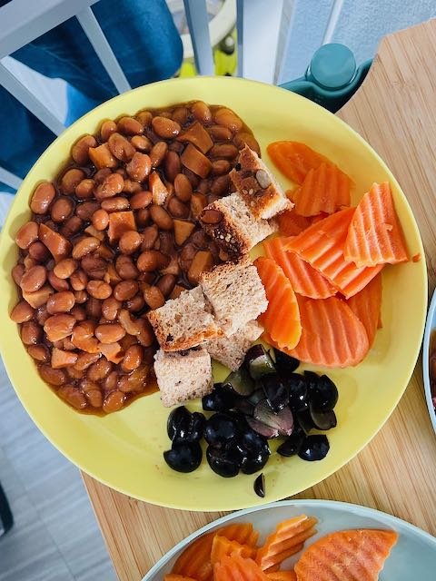 Organic hotdogs and baked beans, carrot chips, homemade bread and grapes