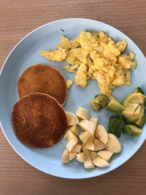 Pancakes, scrambled eggs, avocado, and fresh sliced pears