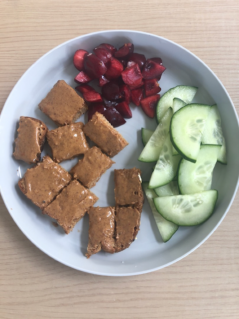 Peanut butter on toast with fresh cherries and cucumbers