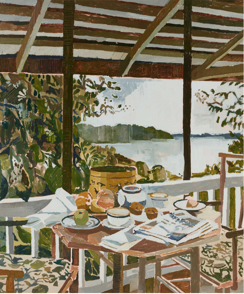 A rustic outdoor breakfast setup on a wooden table with a view of a lake and wooded shoreline, under a wooden roof. The table has bowls, plates, a tea kettle, a cup, and newspapers, with foliage nearby.