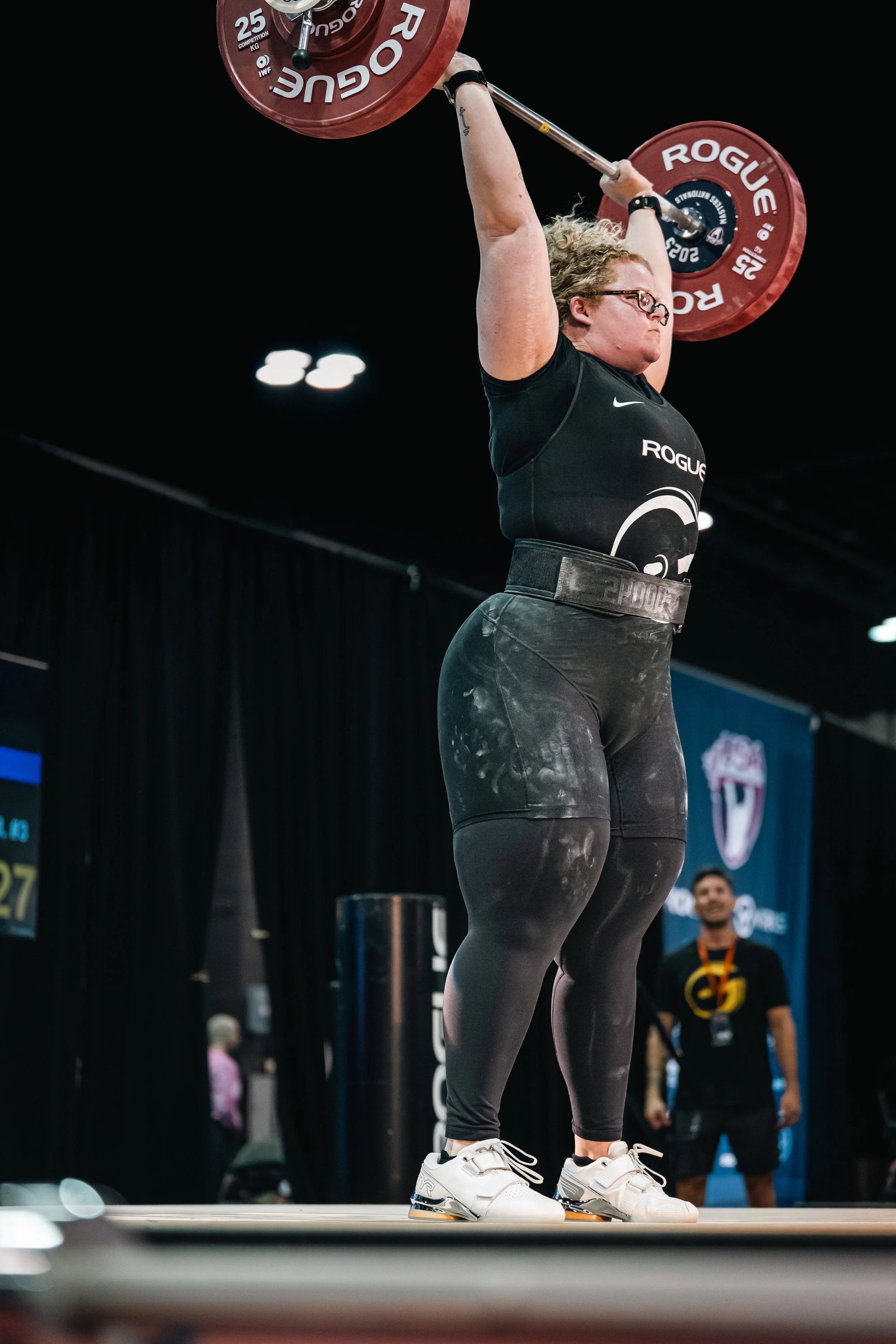 Woman standing tall with a barbell overhead