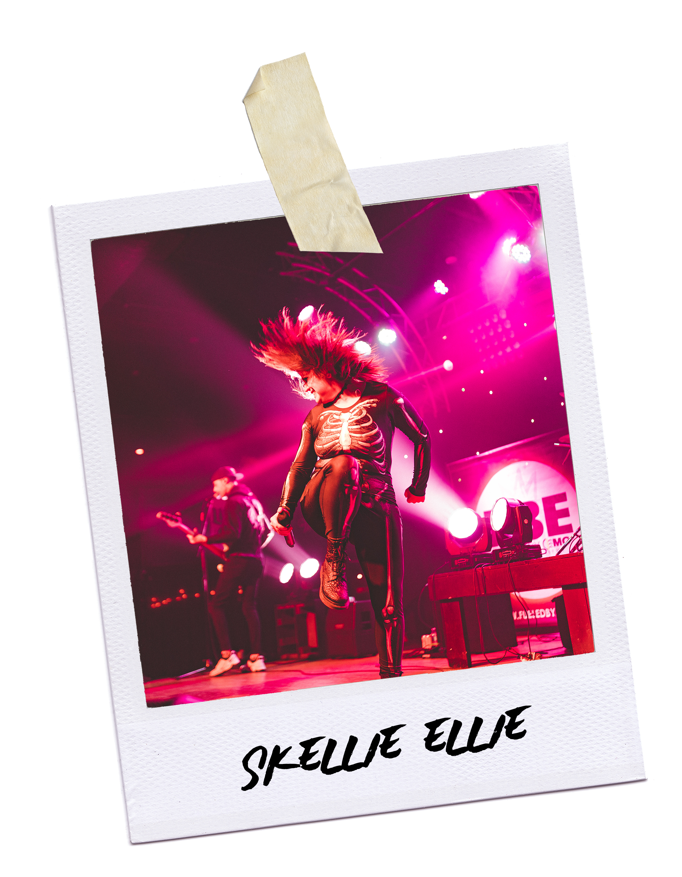 A female performer on stage dancing with pink and purple lighting, wearing a skeleton costume, with a male guitarist in the background, during a live concert.