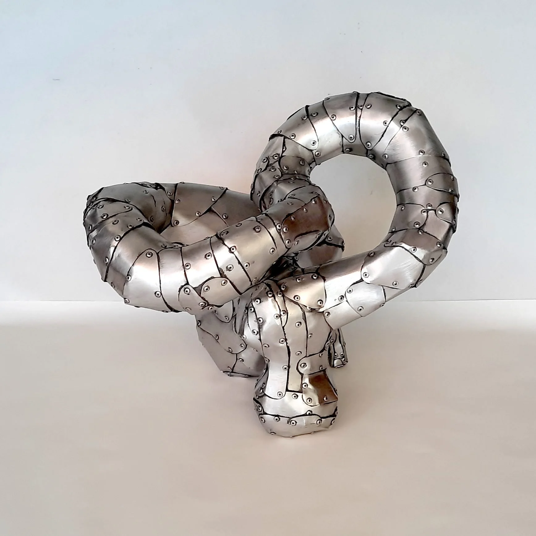 An aspect of a sculpture made of riveted aluminium by Stephen Bond entitled Lump Loop No 4