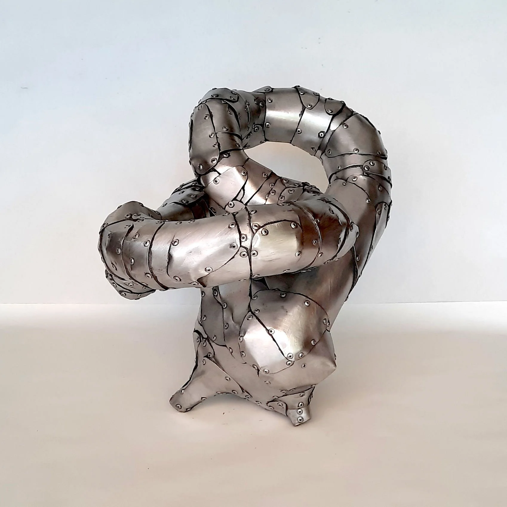 An aspect of a sculpture made of riveted aluminium by Stephen Bond entitled Lump Loop No 4