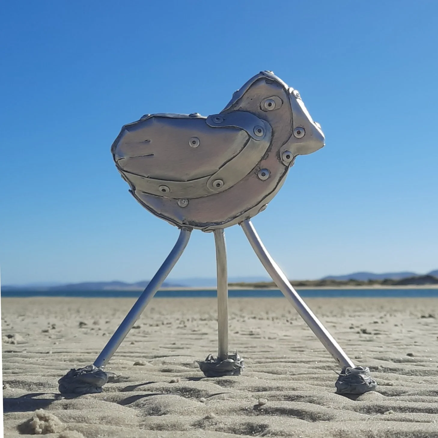 An aspect of a sculpture in a seaside setting made of riveted aluminium by Stephen Bond entitled Endangered Dotteral