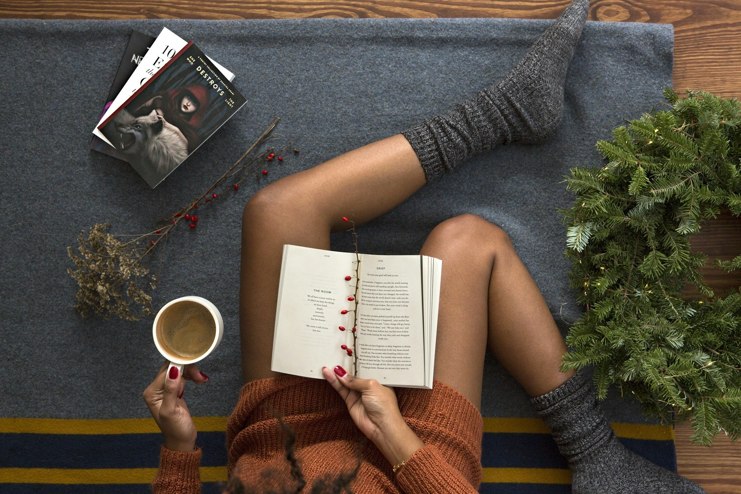 Person relaxing with coffee and a book beside a holiday wreath, representing mindfulness and peace during eating disorder recovery and complex PTSD healing, Orlando, FL.