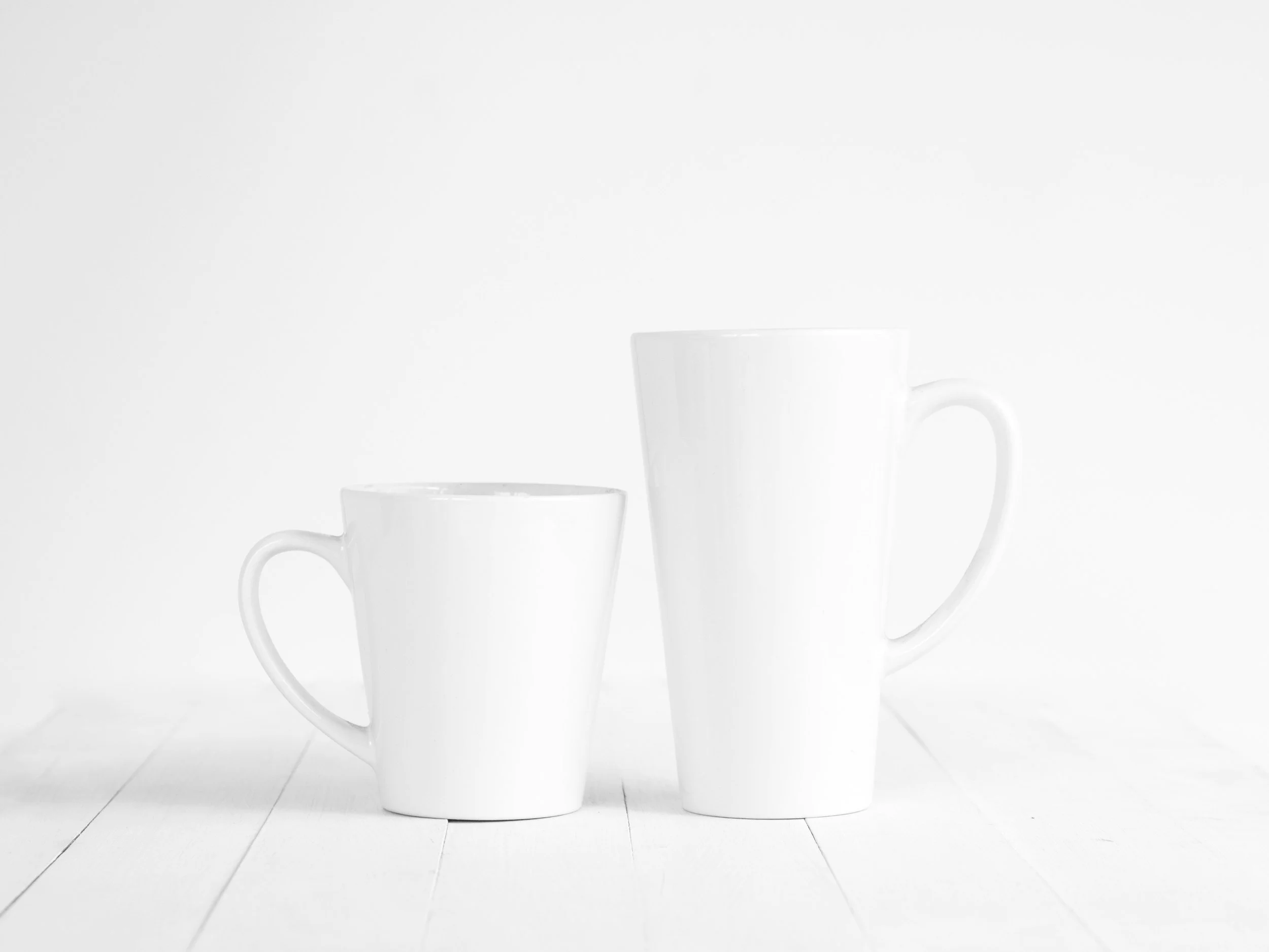 wo plain white mugs on a white surface, symbolizing simple daily anchors and nourishment routines in eating disorder recovery and trauma recovery. Orlando, FL.