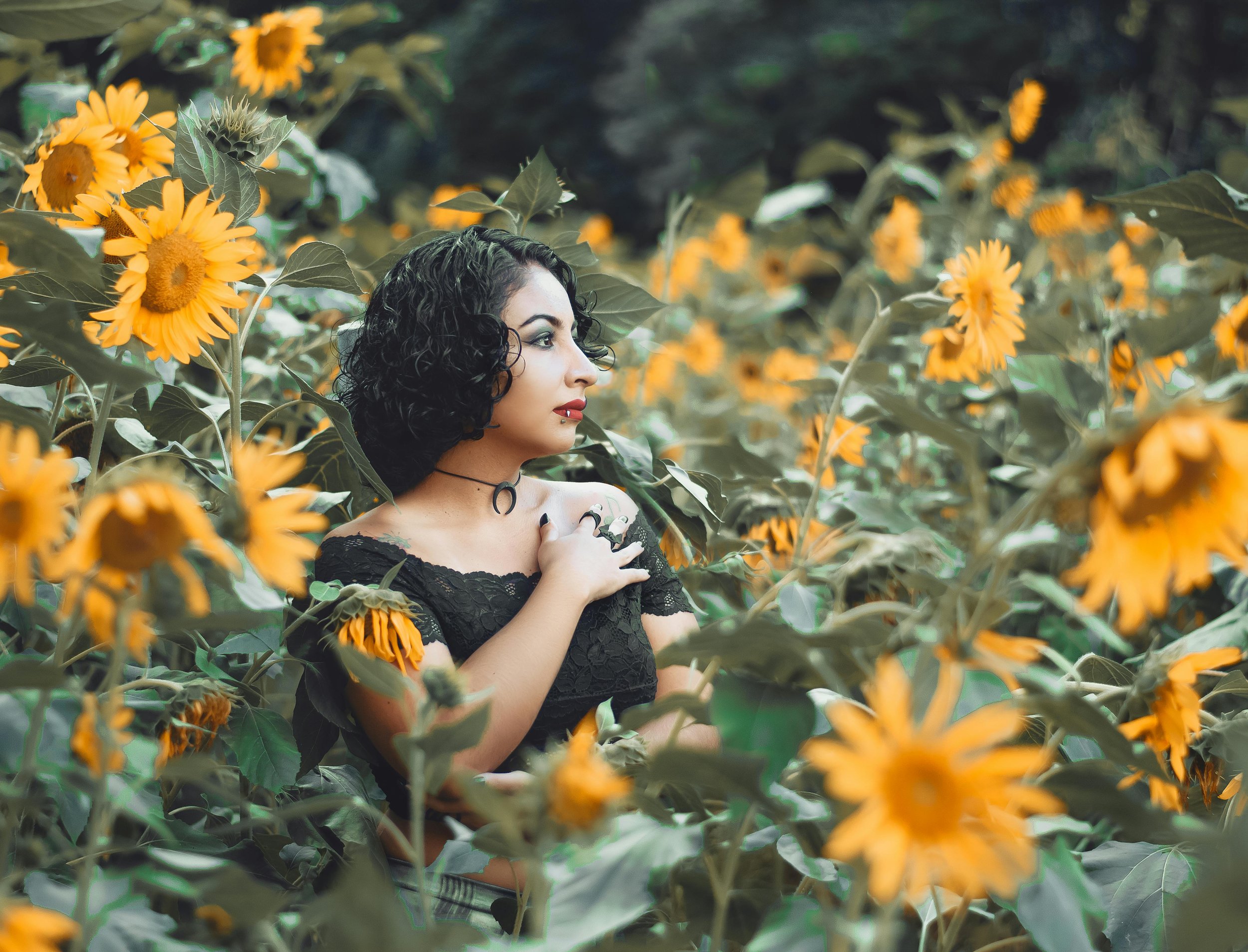 A woman stands in a sunflower field with a hand on her chest, reflecting hope and self-connection found through eating disorder therapy and recovery from disordered eating and complex trauma in Orlando, Florida.