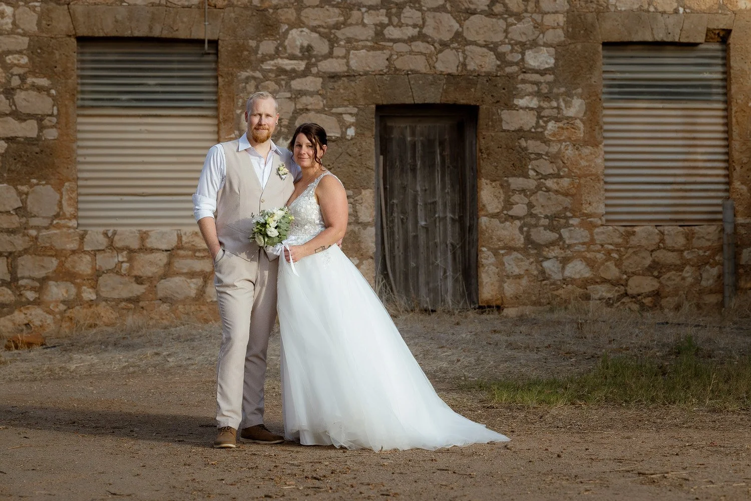 Bride and Groom standing in front of old stone building