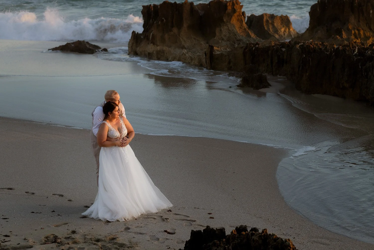 Bride & Groom embrace at Lucy's Beach 