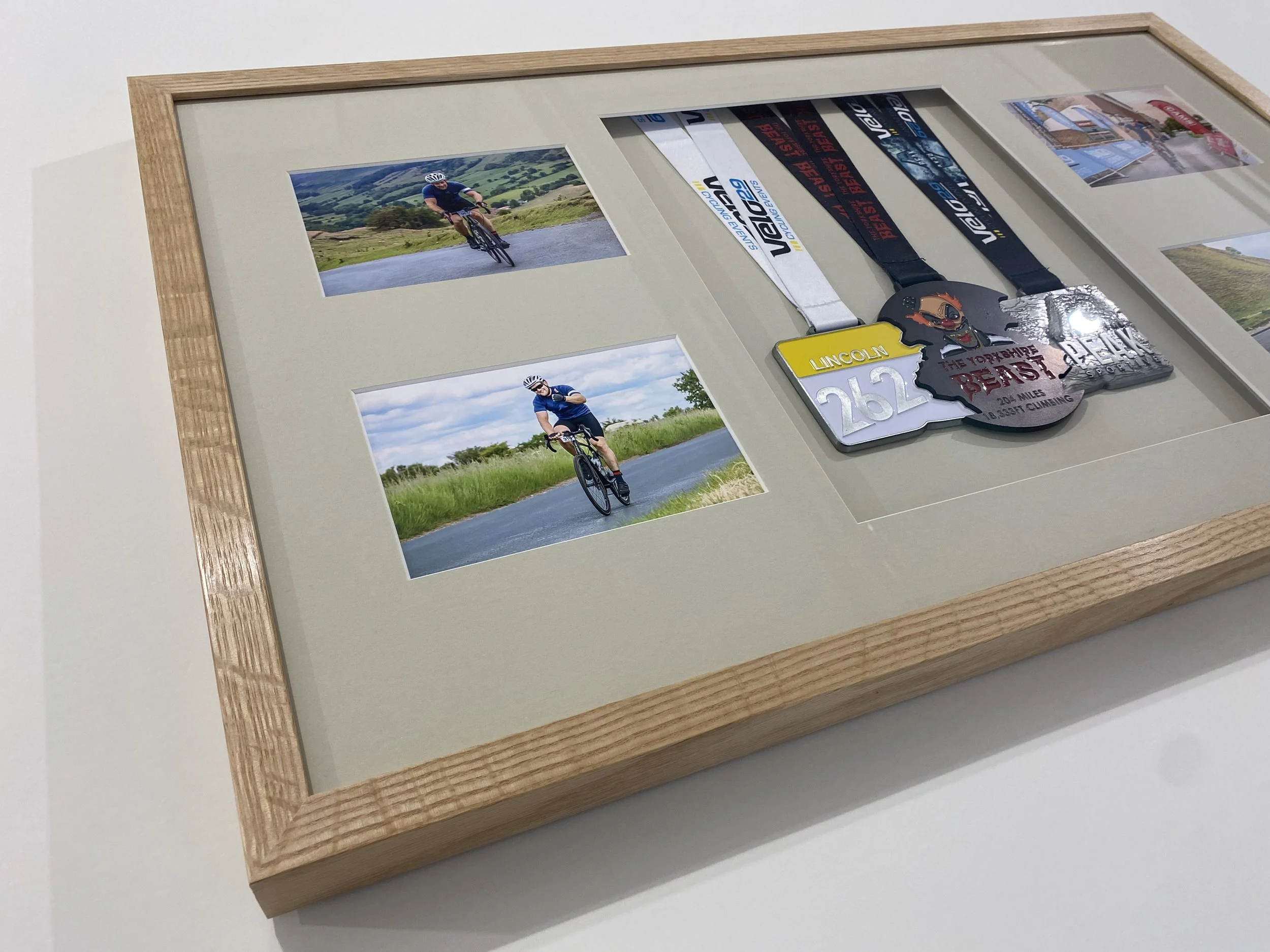 sports medals framed with accompanying photographs in solid oak frame