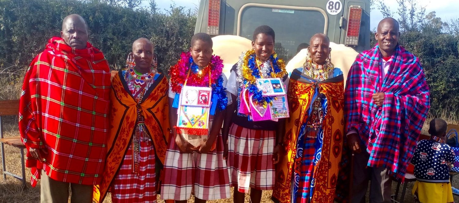  Two graduates with family and village elders 