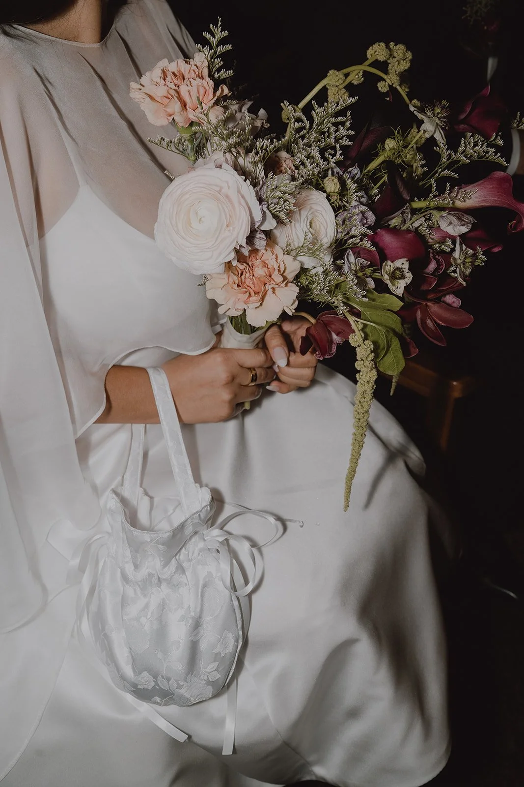 Close up shot of a bride holding her colorful wedding bouquet by Florina Florist.