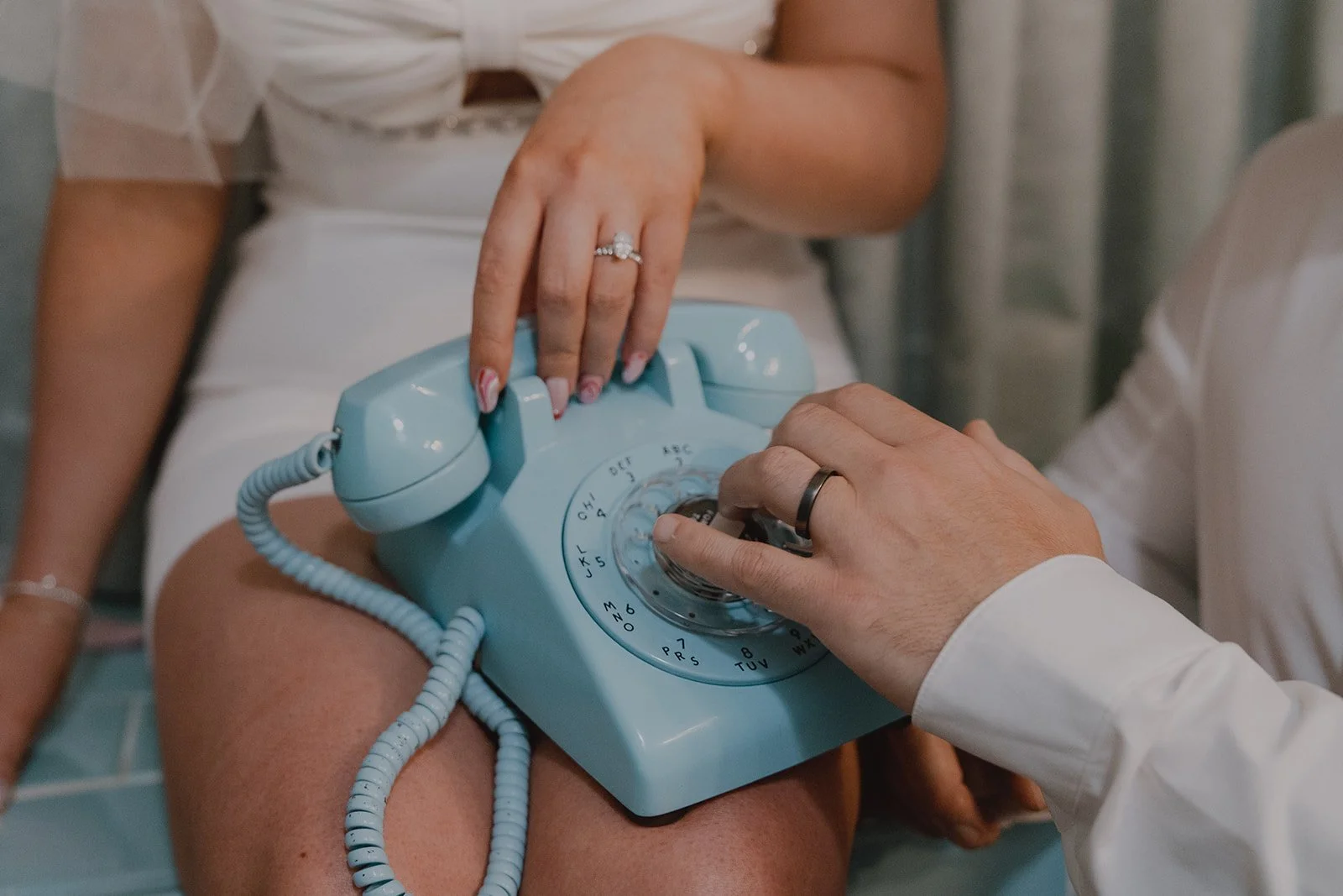 Couple using the vintage blue rotary phone inside Sure Thing Chapel during their Las Vegas micro wedding.