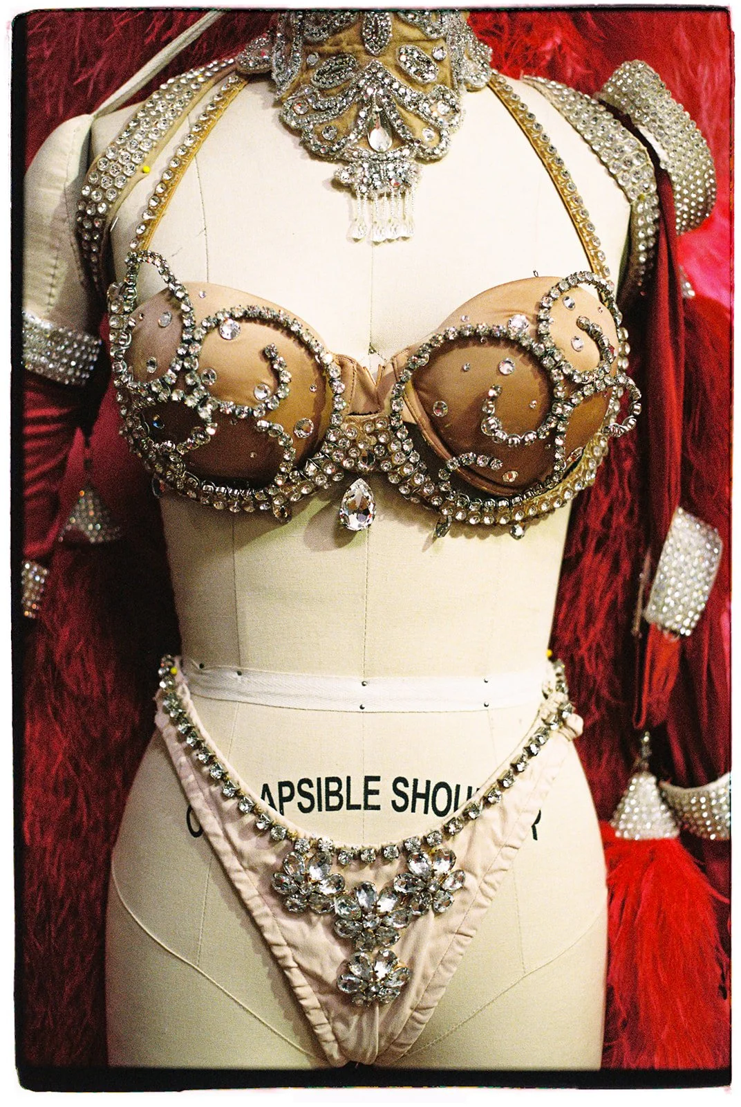 Vintage Las Vegas showgirl costume displayed on a mannequin with feathered details inside the Showgirl Bootcamp wardrobe space.