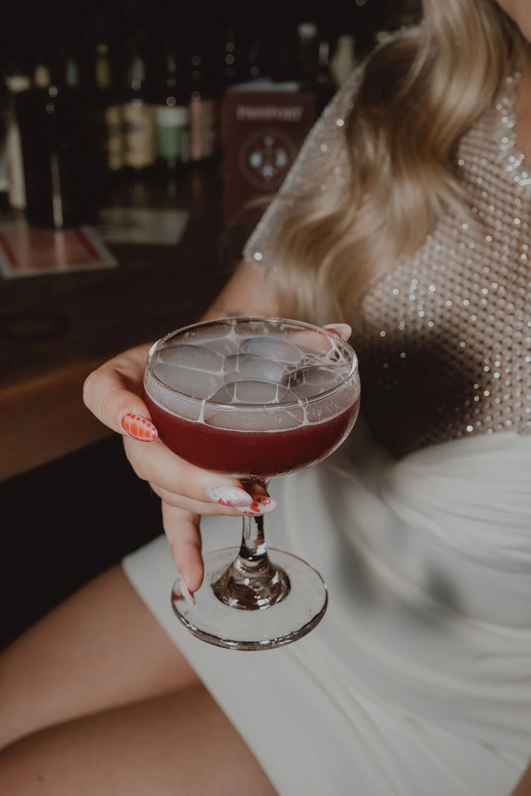 Bride holding a custom cocktail during her Velveteen Rabbit Las Vegas wedding reception.