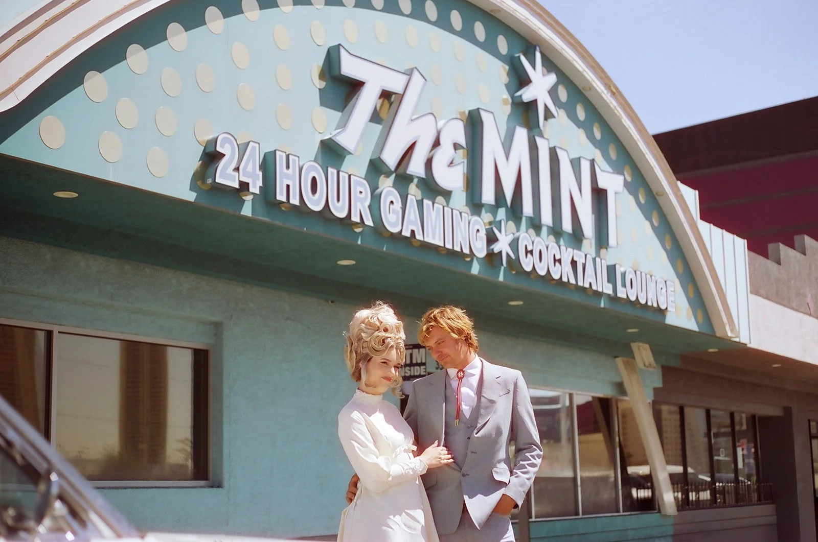 Bride and groom posing outside of The Mint Tavern for their vintage Vegas wedding photos.