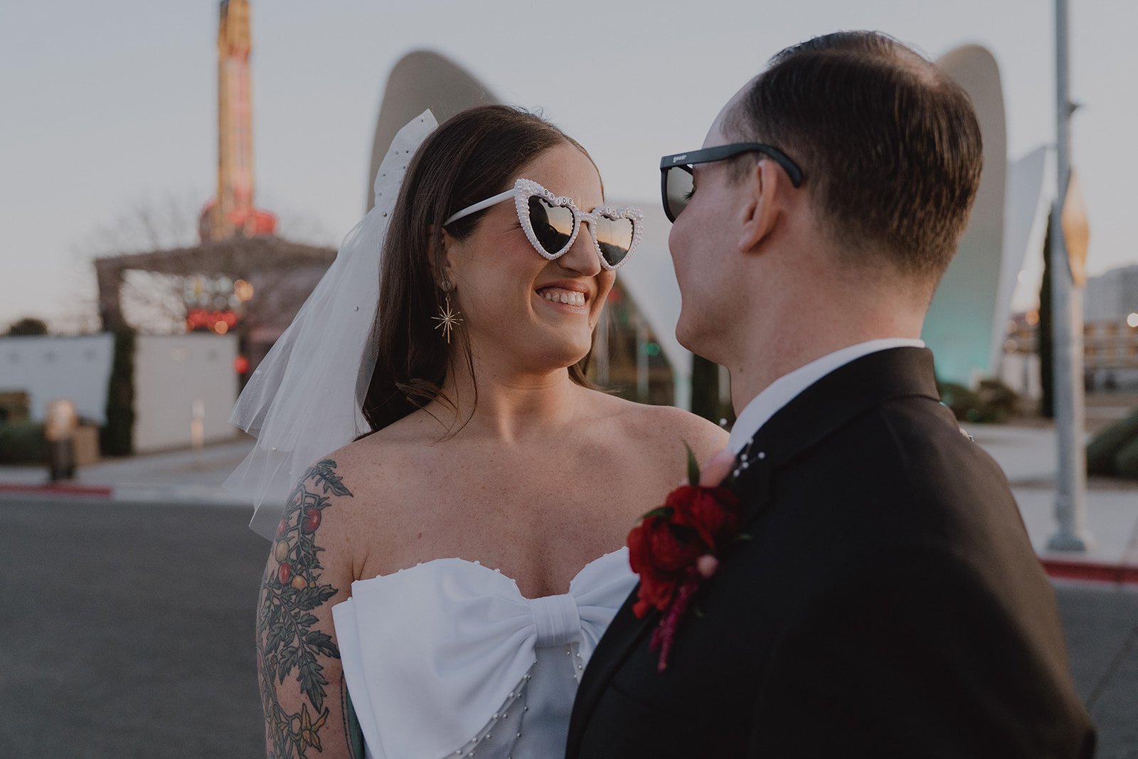 Bride and groom smiling at each other during blue hour outside of Neon Museum in Las Vegas.