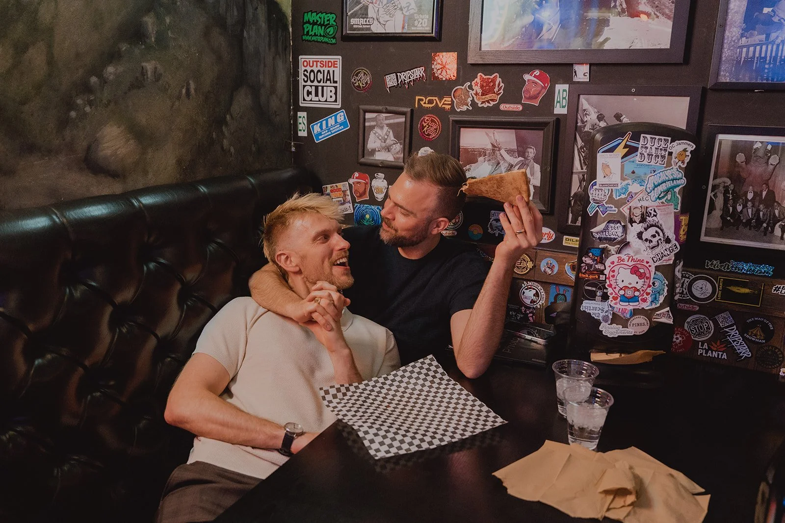Couple cuddling in as booth with pizza at Evel Pie in Las Vegas.