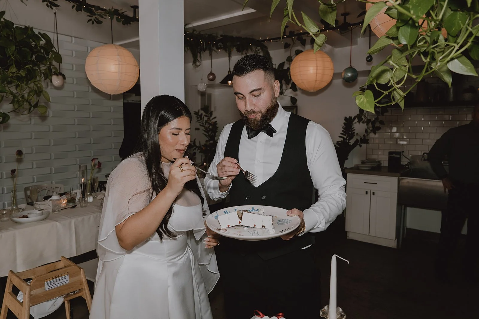Bride and groom sharing a slice from their micro wedding cake.