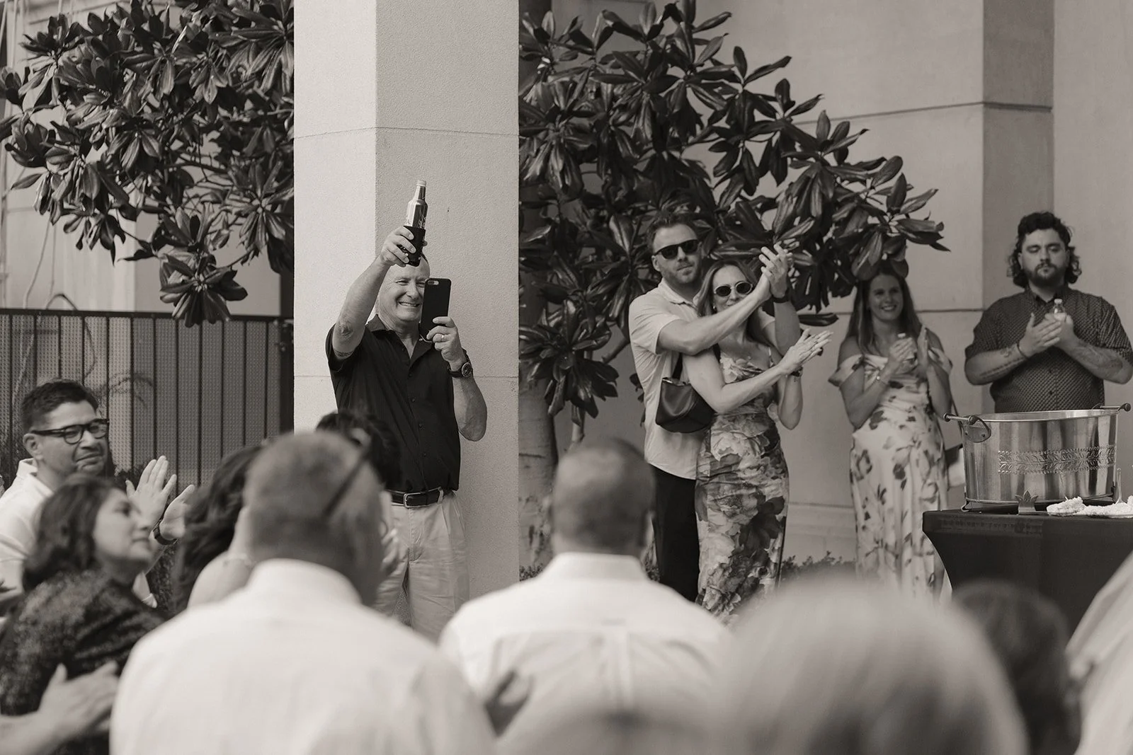 Black and white photo of guests clapping and celebrating during a Caesars Palace Venus Garden wedding reception moment.
