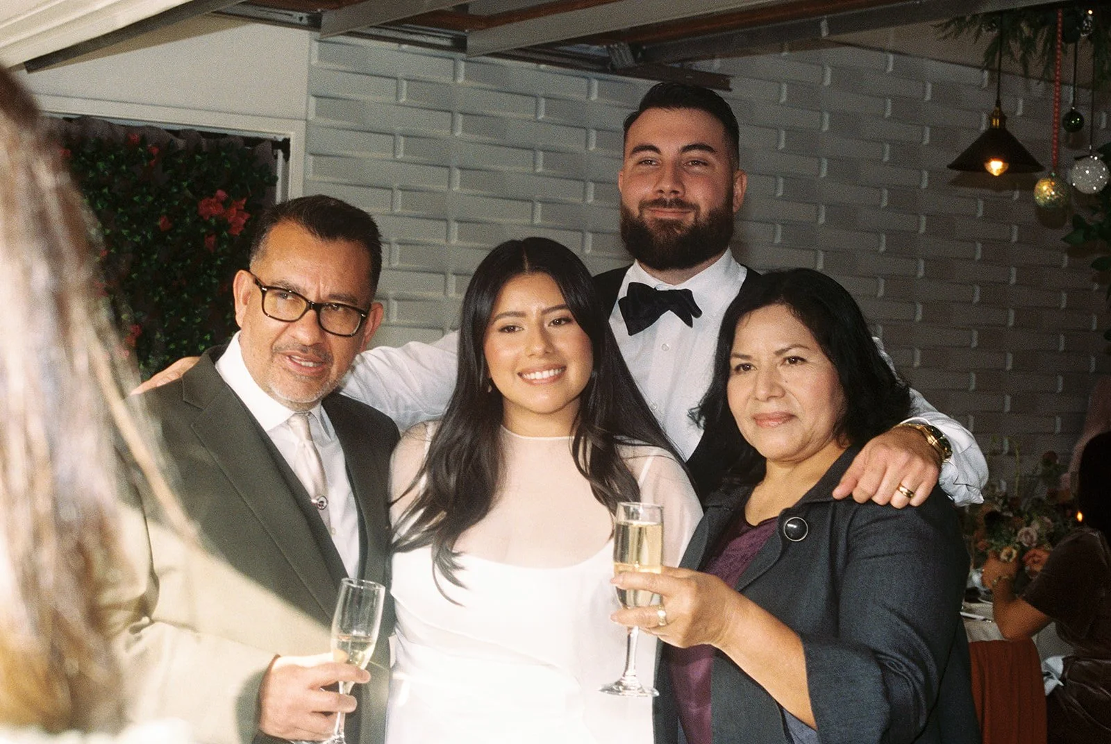 Bride and groom posing for a photo with family members,
