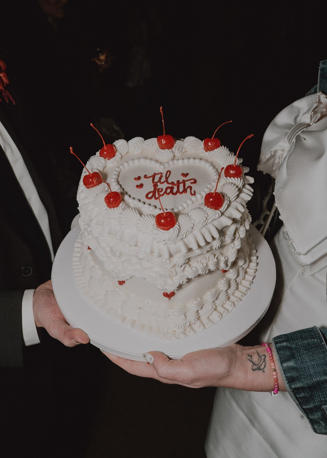 Bride and groom holding their wedding cake at night during their Las Vegas micro wedding.