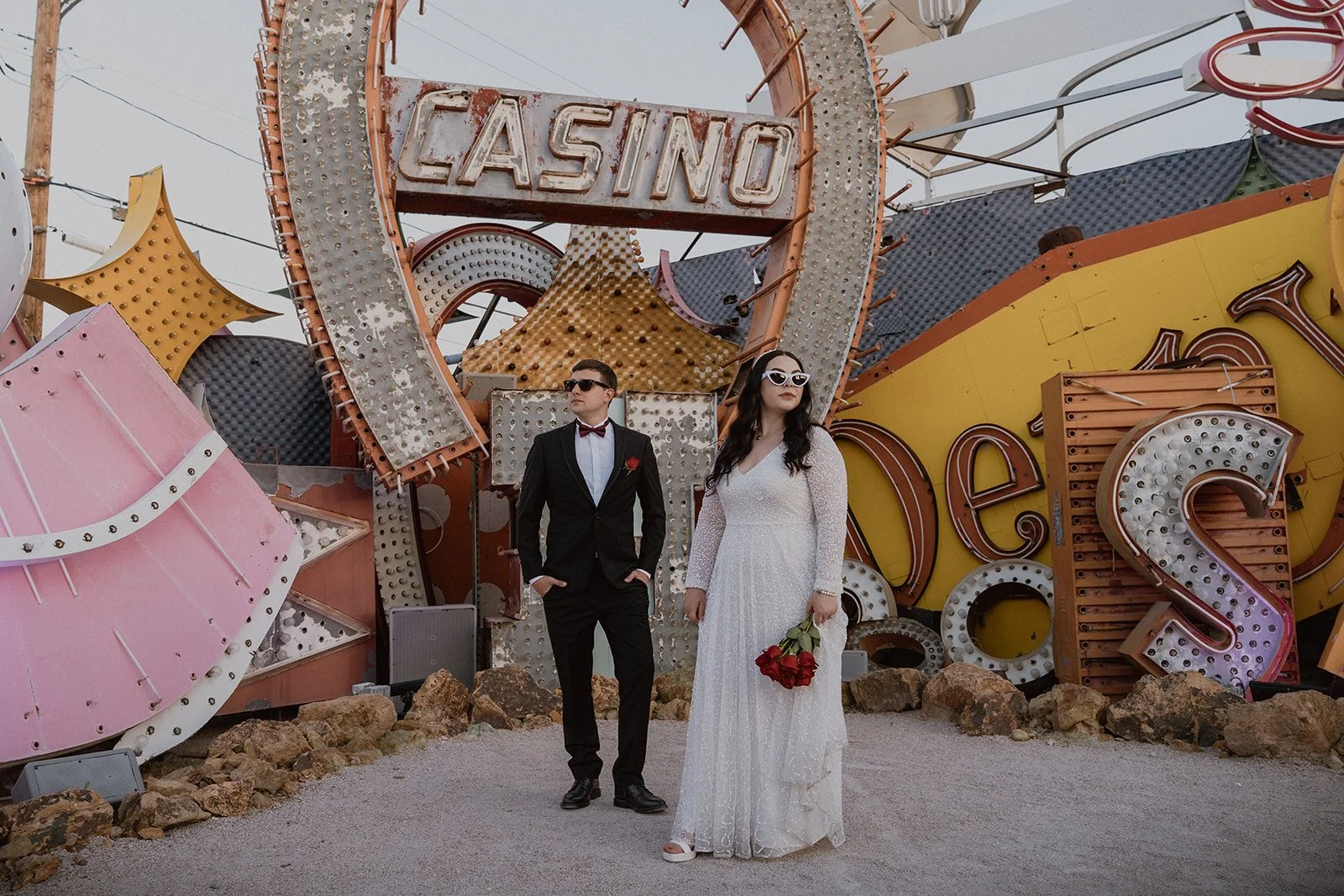 Bride and groom posing in front of an old Casino sign at The Neon Museum in Las Vegas.