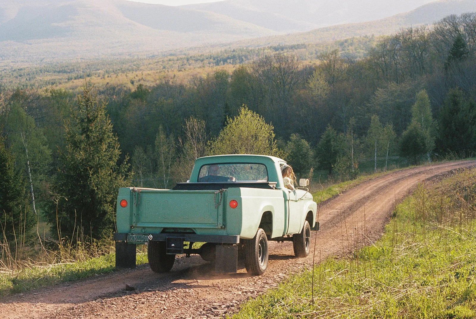 Bride and groom riding back down to Deer Mountain Inn in a vintage green truck.