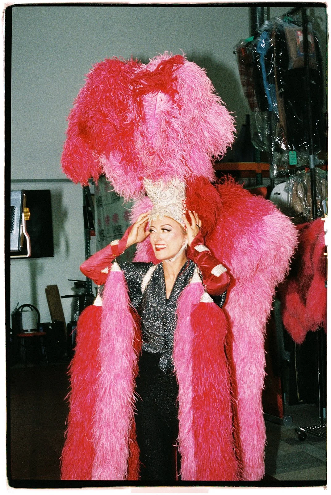 Zoey Goto smiling while wearing a classic showgirl headdress during the Showgirl Bootcamp Experience, photographed on 35mm film.
