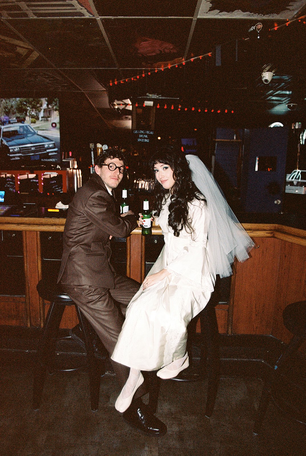 Couple sitting at the barinside Dino's during their vintage Las Vegas wedding photos.