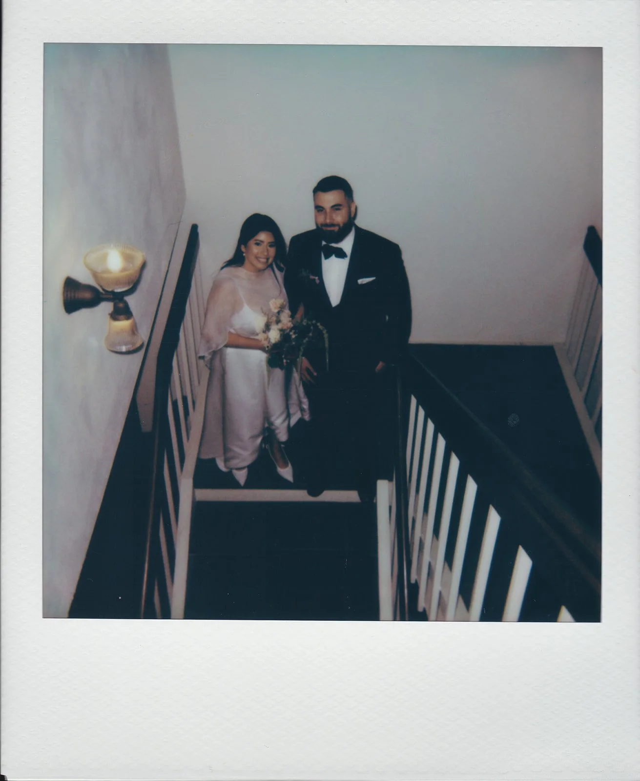 Polaroid wedding photo of a couple posing on the stairs at Old Orange County Courthouse.