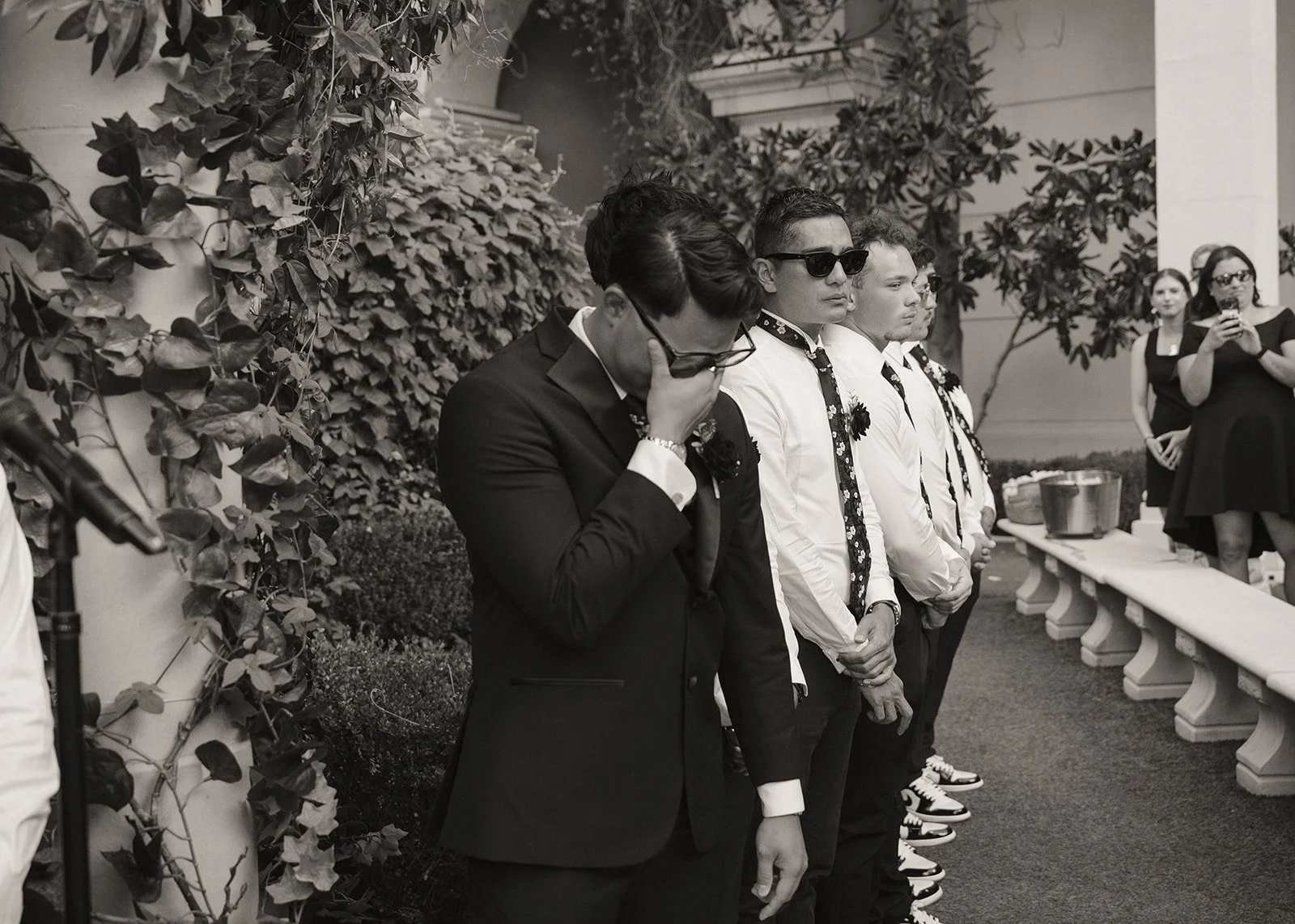 Black and white wide shot of a groom getting emotional during his Caesars Palace Venus Garden wedding ceremony