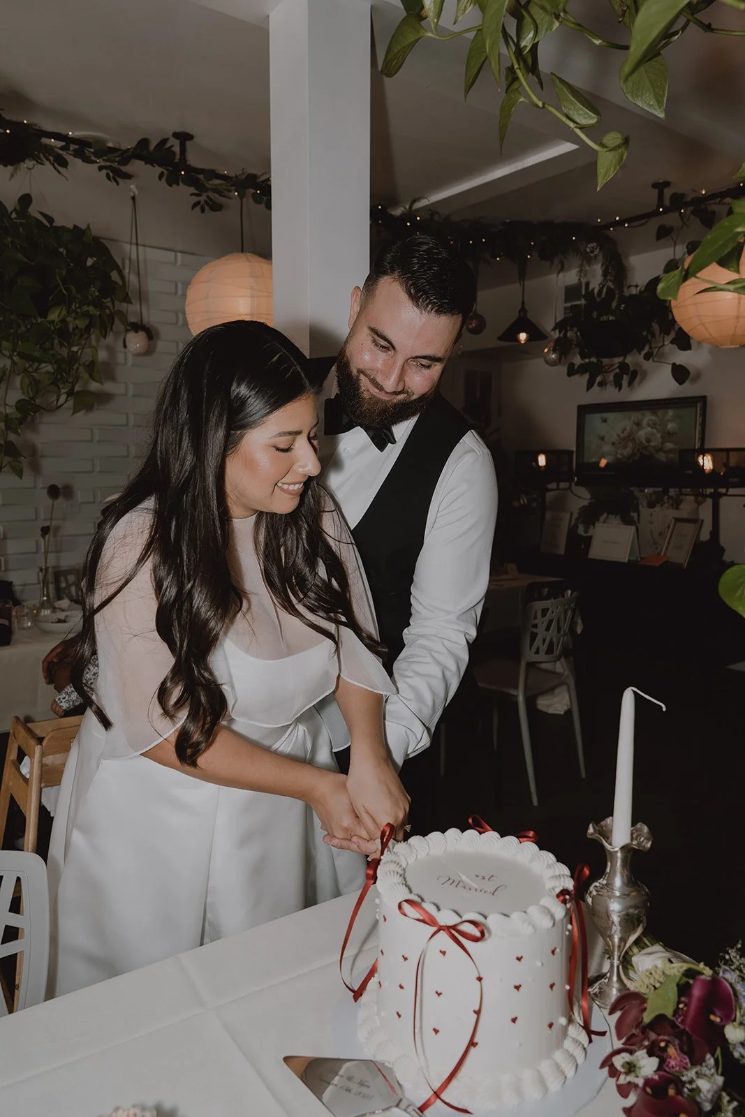 Bride and groom cutting into their wedding cake.