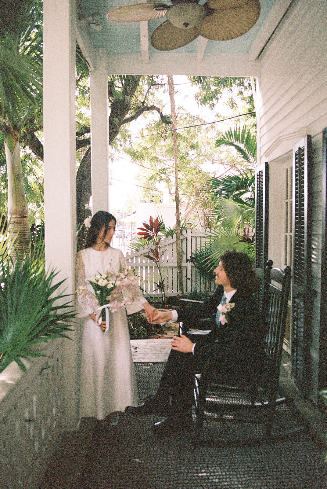 35mm film elopement photo of a couple posing on the porch at Old Town Manor in Key West, Florida.