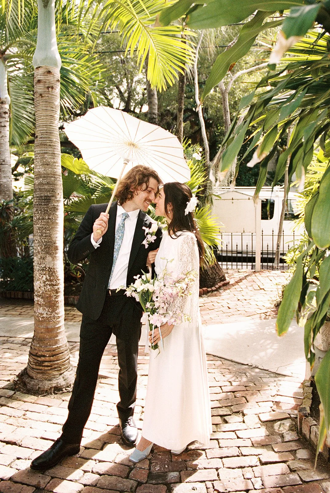 Bride and groom walking the pathways at Old Town Manor in Key West, Florida for their elopement photos on 35mm film.