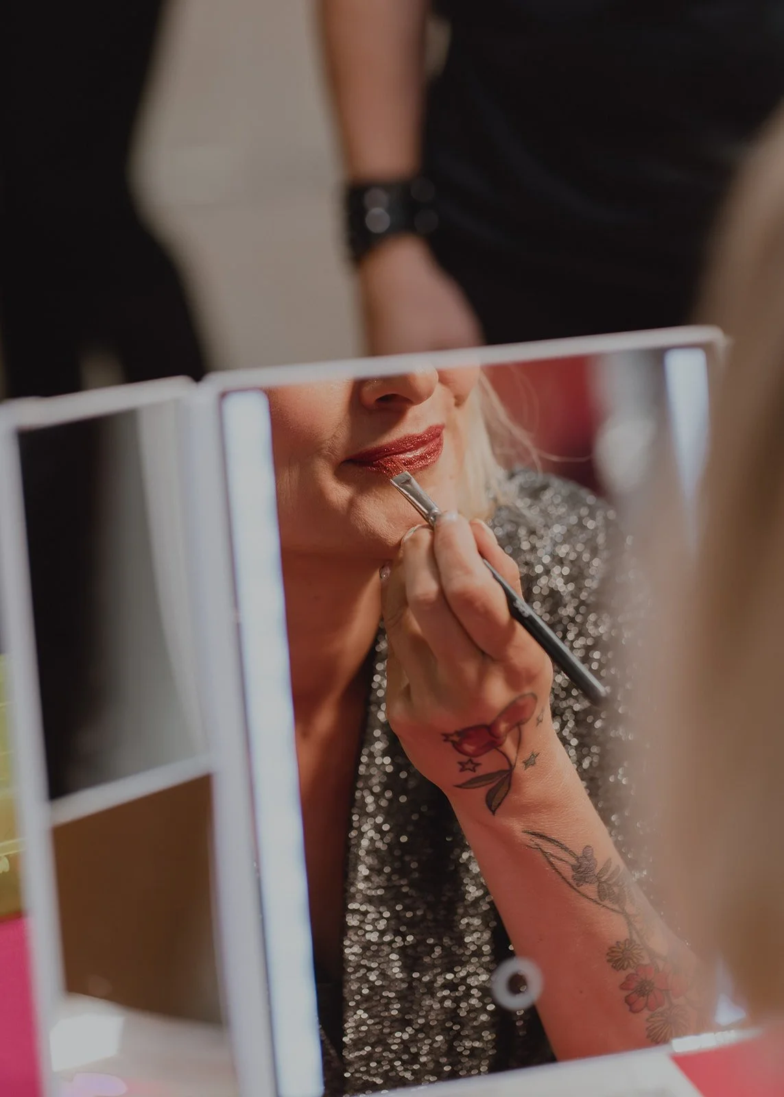 Reflection of Zoey Goto applying lipstick during the Showgirl Bootcamp Experience in Las Vegas.