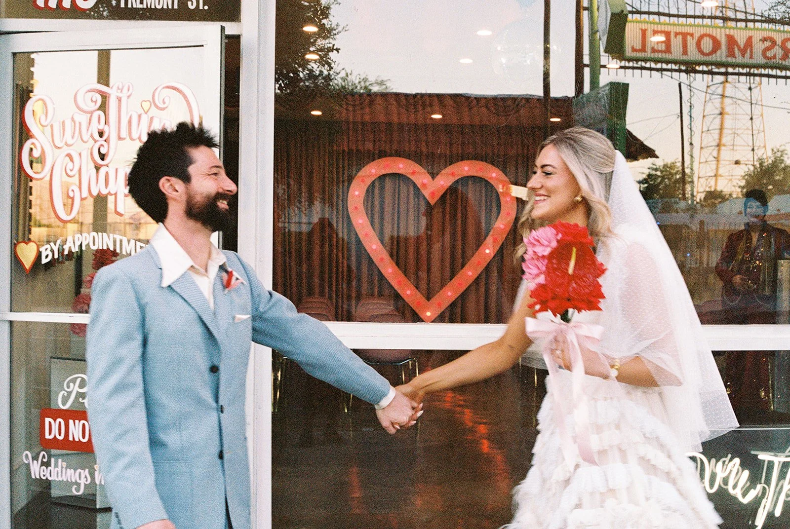 Couple holding hands outside of Sure Thing Chapel in Las Vegas on 35mm film.