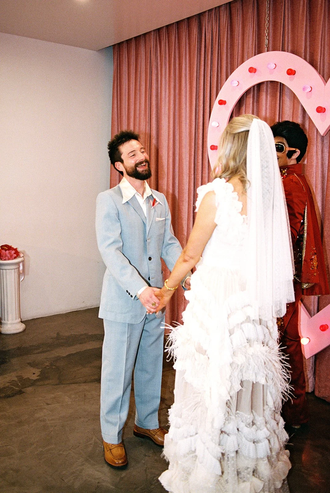 Couple standing at the altar and holding hands during their Las Vegas elopement at Sure Thing Chapel with Lady Elvis.