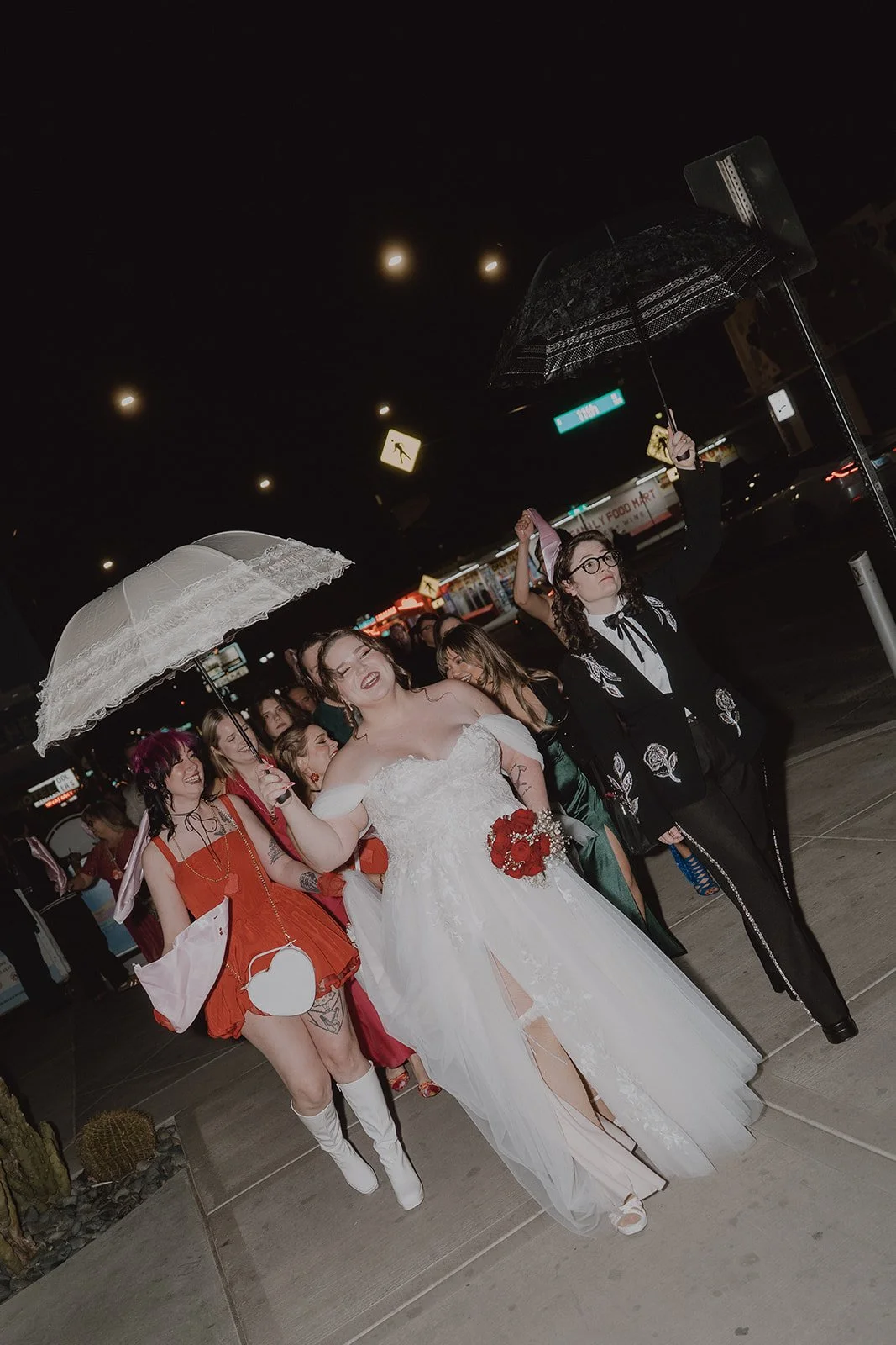 Couple walking through Downtown Las Vegas with their wedding party during a New Orleans style second line parade.
