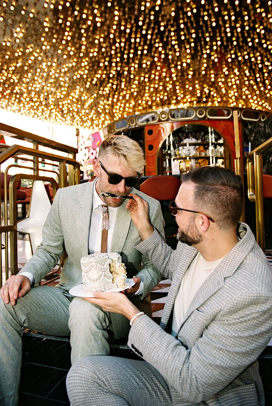 Couple feeding each other cake from their vintage Las Vegas elopement cake.