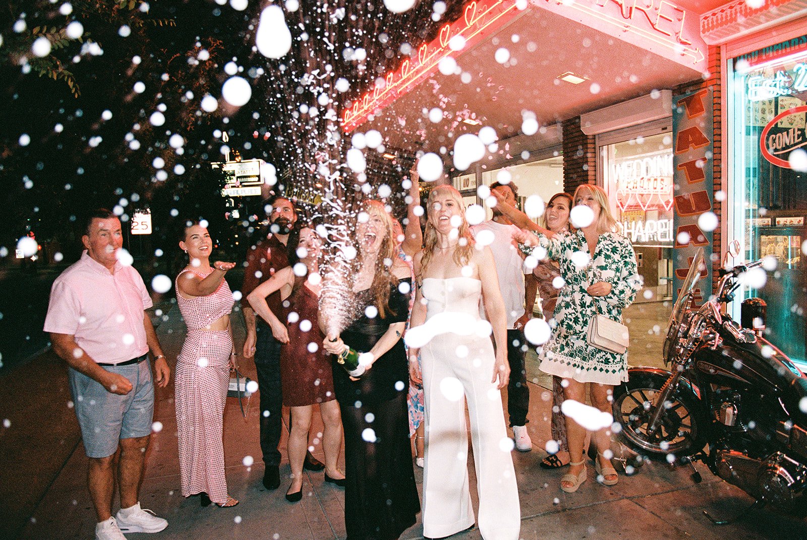 Couple popping champagne in front of Sure Thing Too in Las Vegas.