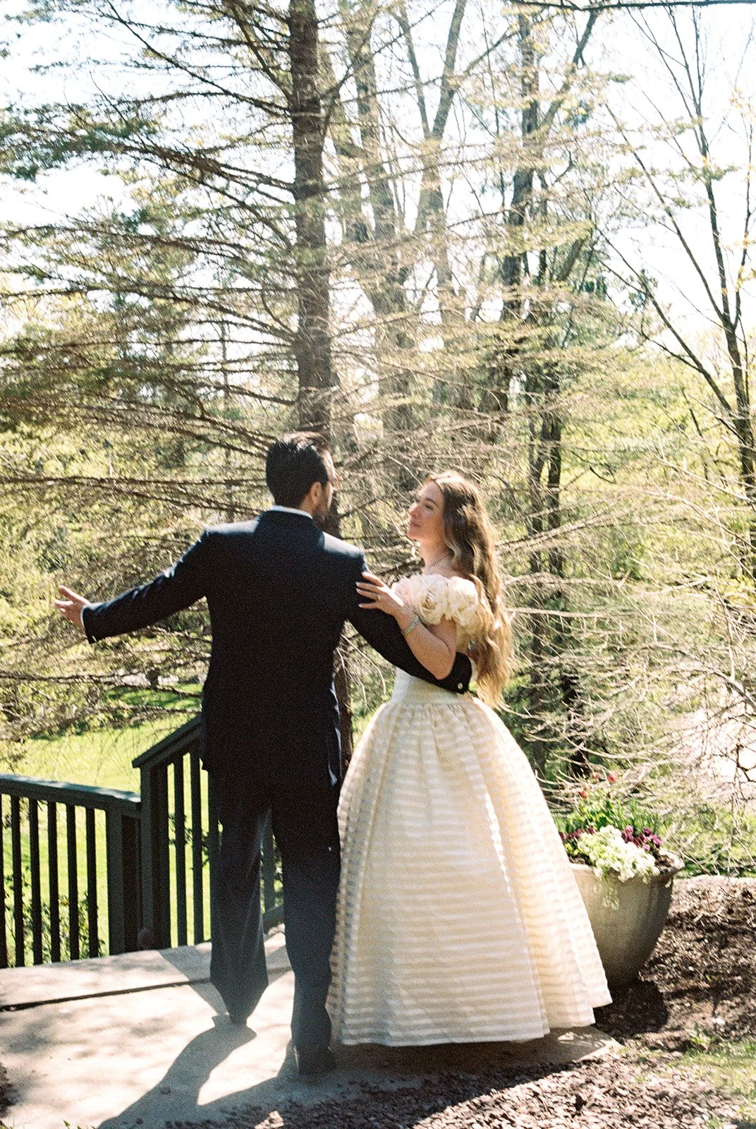 Candid film photo of the bride and groom standing together beneath the trees at Deer Mountain Inn.