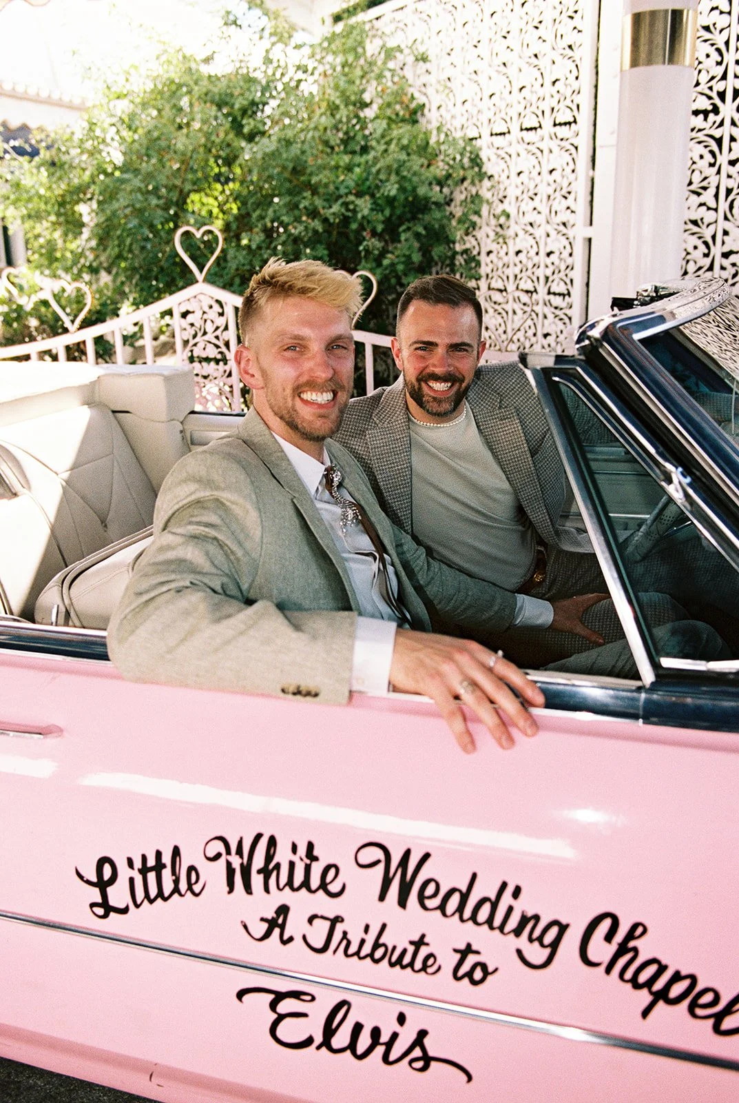 Couple smiling as they sit inside the Pink Cadillac at a Little White Wedding Chapel in Las Vegas.