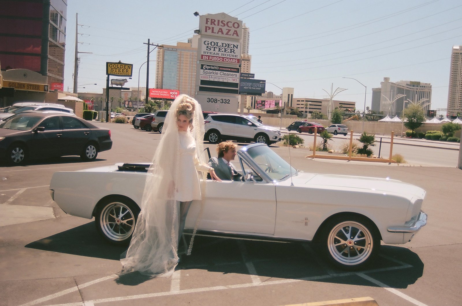 Couple posing with their vintage car from 777 Exotics for their vintage Vegas wedding photos.